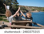 Three sisters over 50 enjoying a picnic by a lagoon on a sunny day