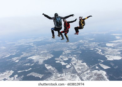 Three skydivers are flying in the sky.