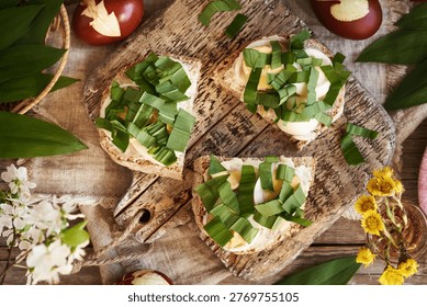 Three slices of bread with leftover Easter eggs and fresh chopped wild garlic leaves collected in spring