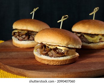 Three Slider Burger With Cheese On A Rustic Table