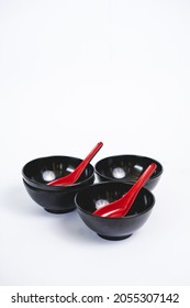 Three Small Black Bowl With Red Soup Spoon On White Background