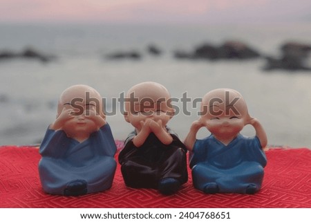 three small Buddha statues with views of the sea behind them