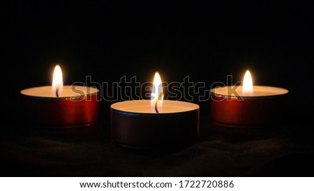 Three small candles in the dark