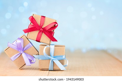 three small gift boxes on a wooden table. greeting card