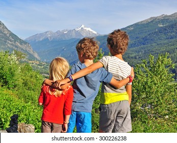 Three small kids hugging in mountains