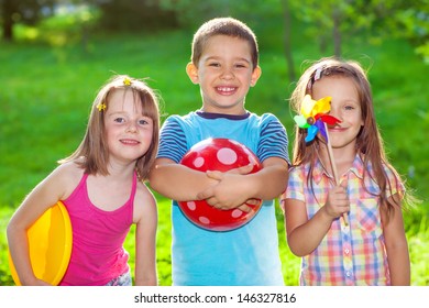 Three Smiling Kids In A Summer Park