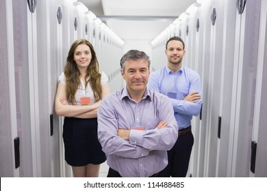 Three Smiling People Standing In Data Center With Arms Crossed