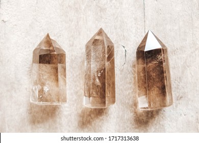 Three Smoky Natural Quartz Crystals On Wooden Background. Top View. Copy, Empty Space For Text