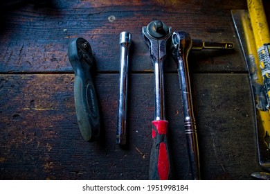 Three Socket Wrenches With An Extendable Socket On A Old Wooden Work Bench 