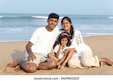 Three souls bask in the sun’s warmth, sharing laughter and love by the gentle waves.