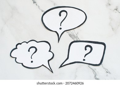 Three speech bubbles with question marks on a white background