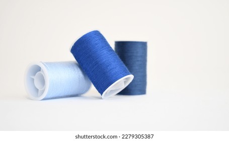 Three spools of blue yarn in different shades on a white background - Shutterstock ID 2279305387