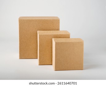 Three square craft boxes of different sizes stand on a white background, mockup, copy space