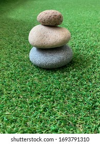 Three Stacked Stones On The Grass