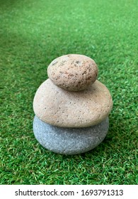 Three Stacked Stones On The Grass