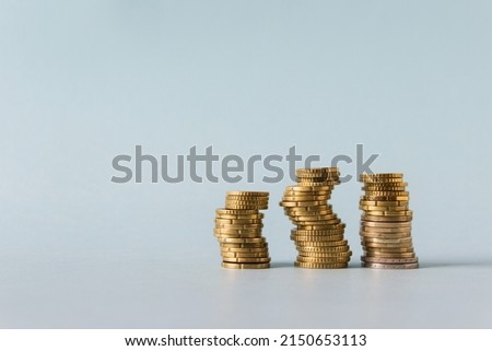 Three stacks of yellow coins on blue background. Image with copy blank space.