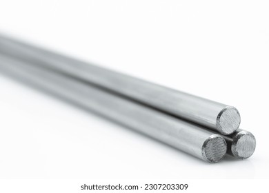Three Stainless steel metals bars against white background with tiny reflection shot from an angle. Long. 