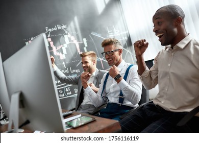 Three Stock Traders Are Happy With The Results While Looking At Graphs, Indexes And Numbers On Screens. Blackboard Full Of Charts And Data Analyses In Background. Stock Trading, People Concept