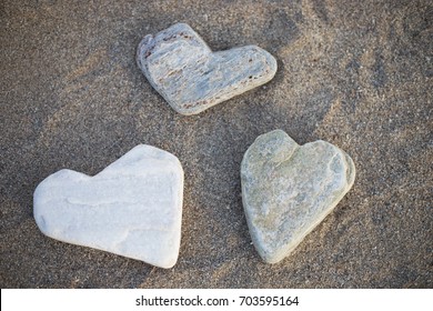 Three stones shaped in a form of hearts are on the beach by the sea. Holiday mood collection of people for good luck, happiness, love, to remember good moments of the travel to an interesting place. - Powered by Shutterstock