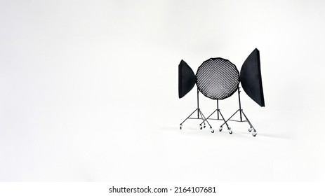 Three studio lights of a softbox and an octobox stand against the background of a white cyclorama.