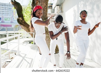 Three Stylish African American Friends, Wear On White Clothes. Street Fashion Of Young Black People. Black Man With Two African Girls Dancing Gangsta Rap Style.