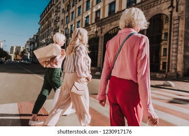 Three Stylish Older Ladies Are Going To Shopping Center While Crossing Crosswalk