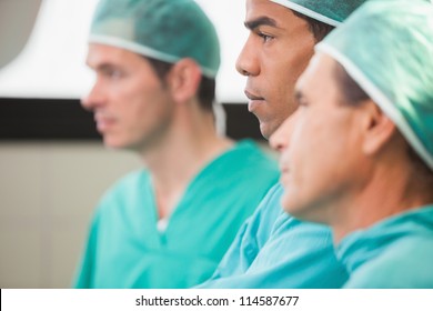 Three Surgeons Thinking In Operating Theatre