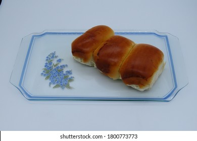 
				Three sweet and salty breads in a decorated glass tray. Exclusive bread  from Brazil named "Pão de cará" in portuguese.