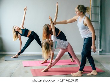 Three teenage girls doing yoga in the gym with the instructor. A healthy satisfied active sports lifestyle. Morning exercises and stretching. - Powered by Shutterstock