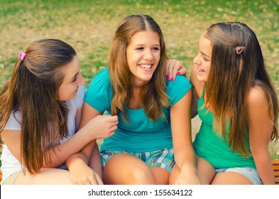 Three Teenage Girls Talking And Having Fun In The Park.