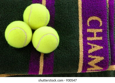 Three tennis balls on a purple and gold towel