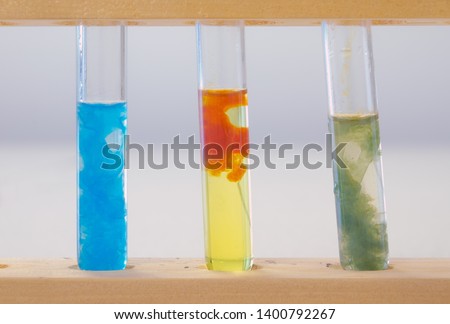 Three test tubes containing (left to right) precipitate of copper hydroxide, precipitate of iron (III) hydroxide and precipitate of iron (II) hydroxide. All were made by adding sodium hydroxide.