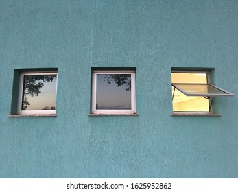 Three tiny windows in a blue wall