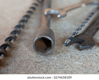 Three tools are shown on a grey surface. The first is a wrench, the second is a pair of pliers, and the third is a pair of clippers.
