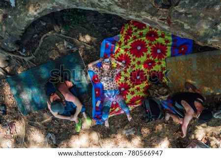 three tourist relax on the rug in the ground in shrilanka forest