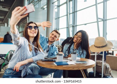 Three tourists makes selfie on phone in airport - Shutterstock ID 1369165415