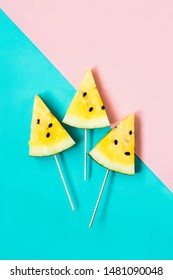 three triangular ice cream slices on a stick of ripe yellow watermelon