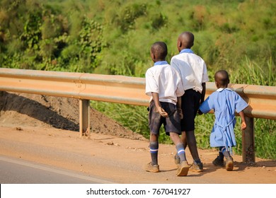 Three Unidentified African Schoolchildren Walking Along The Dangerous Highway. Road Accidents Are Prone In Africa Due To Lack Of Control And Few Licensed Drivers