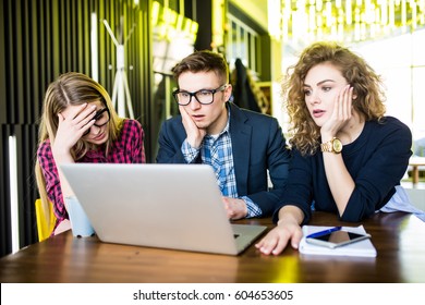 Three upset friends online using a laptop with problems in a coffee shop