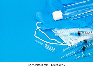 three vaccines for covid in ampoules, syringes ,face masks, sanitizer and gloves lying on blue background - Shutterstock ID 1908003445