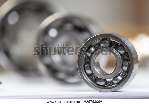 Three various ball bearings lying on table.
Automotive spare part sale company. Heavy industry engineering
company. Machinery designing and manufacturing. Steel details for
engine mechanisms.