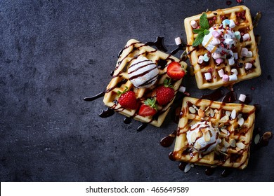 Three various belgian waffles on dark wooden background. From top view