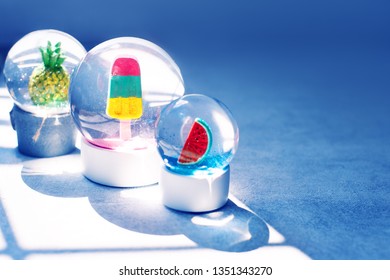 Three various snow globes with watermelon, ice cream and pine apple summer trends. Christmas on the beach concept - Powered by Shutterstock