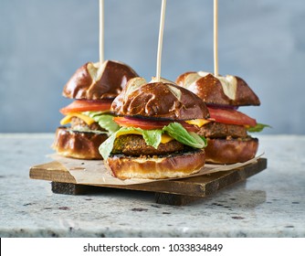 Three Vegan Burger Sliders With Pretzel Buns