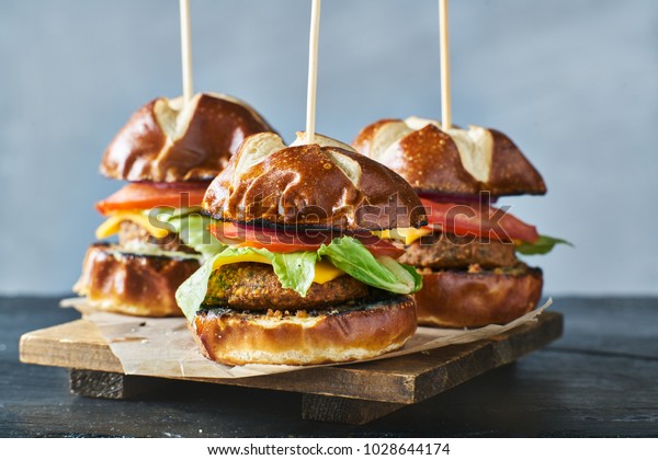 three vegan burger\
sliders with pretzel buns