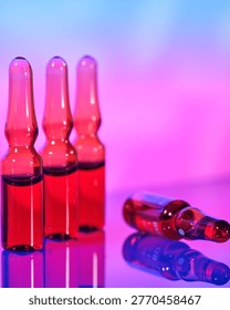 Three vials filled with red liquid stand upright on a shiny surface, while one vial lies on its side. The background has vibrant colors that create a lively atmosphere.