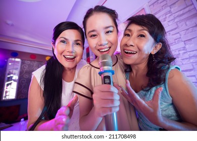 Three Vietnamese Women Singing A Song In The Karaoke Bar