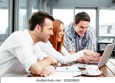 Three Web Designers Looking At A Laptop Screen