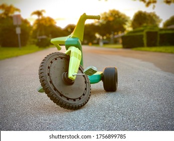 Child’s three wheeler . Big wheel toy in the road. tricycle with plastic wheels. Classic vintage childhood big wheeler. Traditional tricycle