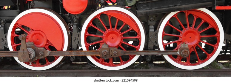 Three wheels of steam locomotive on rails closeup 